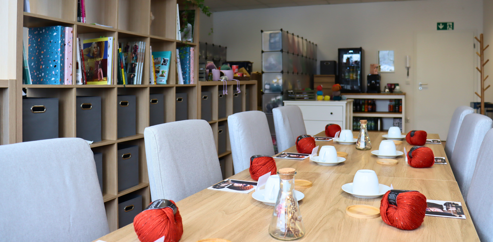 Workshoptisch mit Kaffeetasse, Wolle und Strickanleitungen