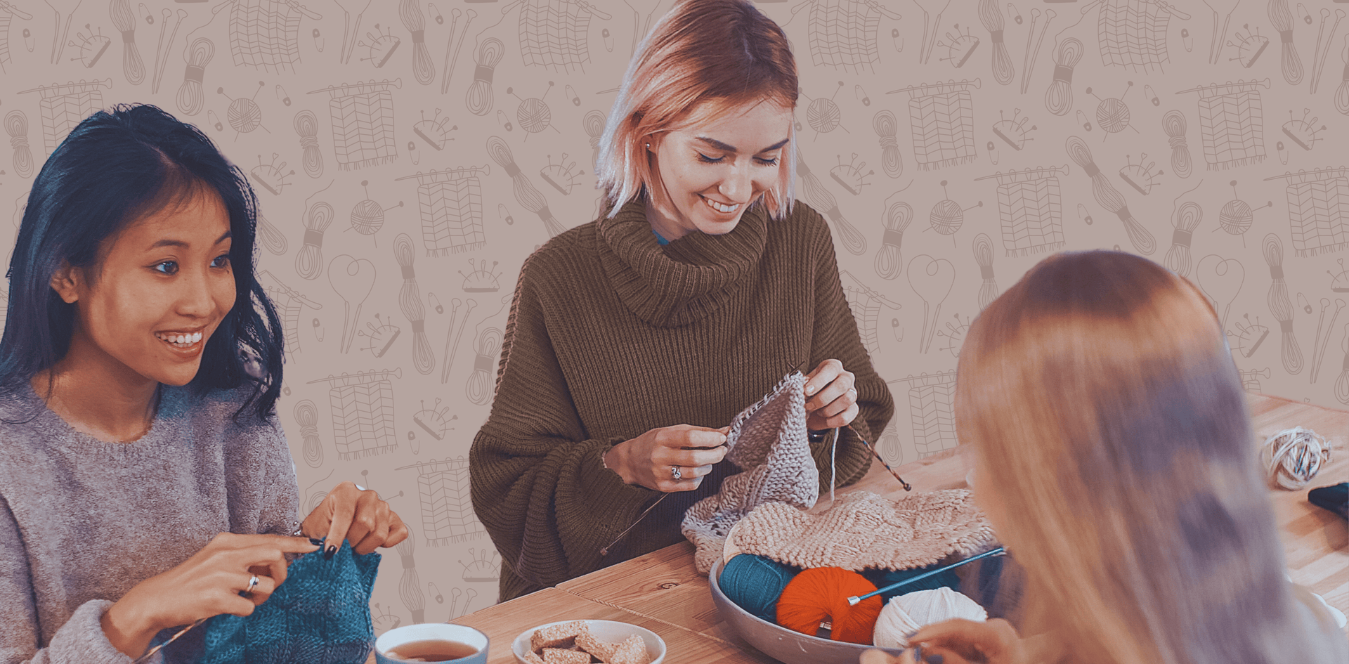 Bild von Frauen die stricken und sich unterhalten, am Tisch sind Tee, Kekse und Wolle in unterschiedlichen Farben.