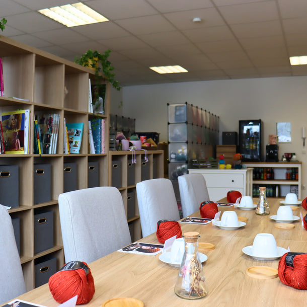 Workshopraum mit Strickbücher, Kaffeetasse, Wolle und Strickanleitungen